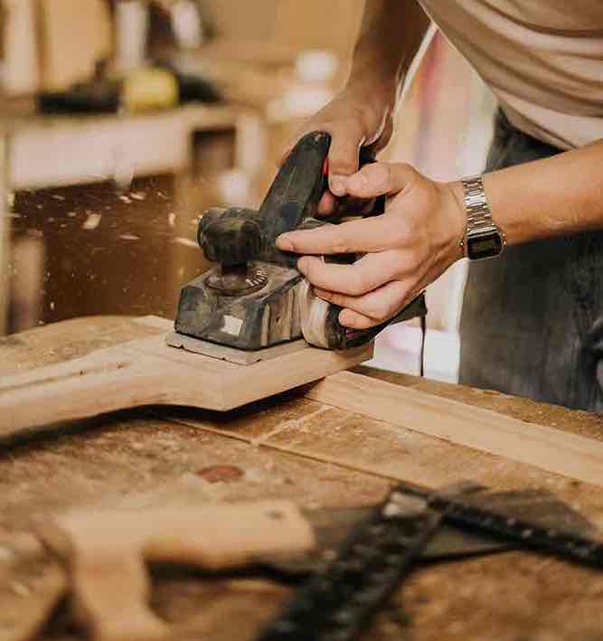 Falegname al lavoro con pialla elettrica: la competenza e la pratica deliberata come fondamento della passione professionale, non il contrario